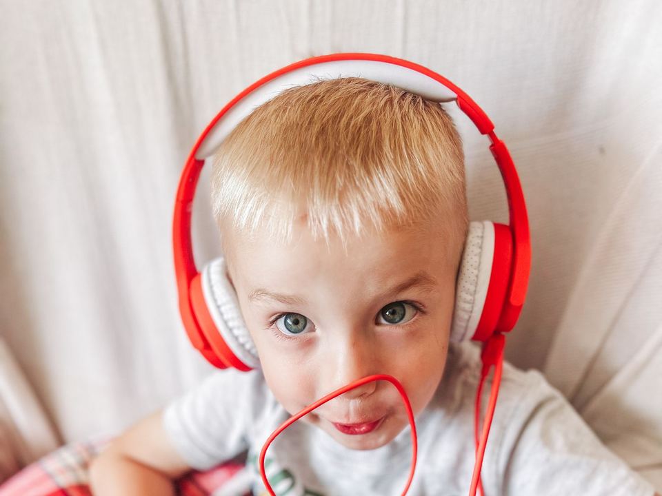 Young boy wearing red headphones